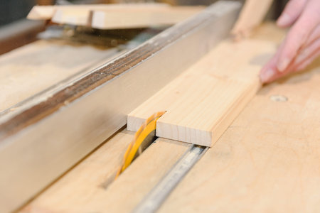 Saw the tree in the home workshop. A man sawing boards. Professional tools at work. Joinery.