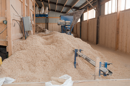 Production of fuel briquettes. Briquettes from sawdust. Pressed chips in briquettes. Sawdust for fuelの写真素材