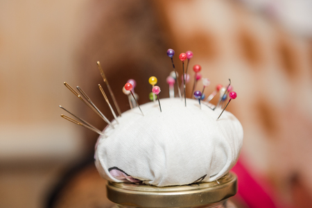 A lot of needles. Needles stuck in the sponge. Needle holder. Needles for sewing. Needles at home.の写真素材