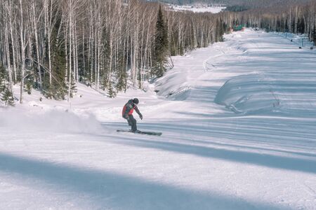 A skier rides from a high mountain. Ski resort. Active lifestyle. Health. Russian sportの写真素材