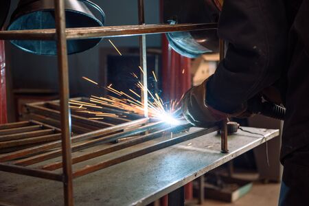 The welder makes the part. Worker welds the details. Master of semi-automatic welding. Welding.の写真素材