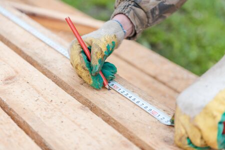 Measure with a ruler on the tree. Measure the distance with a ruler. Measure on the board. Centimeter on the tree. Construction works. Build a houseの写真素材