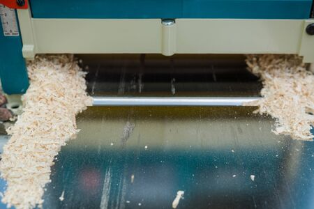 planing boards on a thicknesser. wood shavings. machine for planing wood. carpentry work. joiner's machine. wood processing.の写真素材