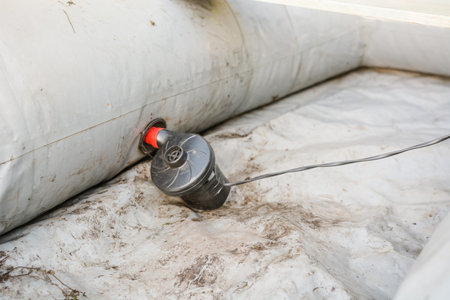 inflate a rubber boat. repair the pump in the boat. man thinks up a boat. preparation for fishing. fishing gearの写真素材