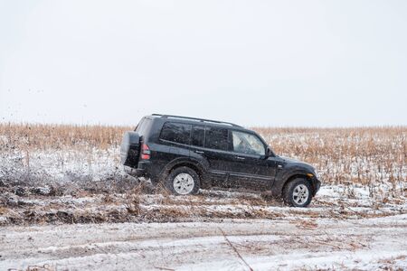 off-road driving. in a jeep on the first snow. car in the mud. driving through the mud in a simple car. off roadの写真素材