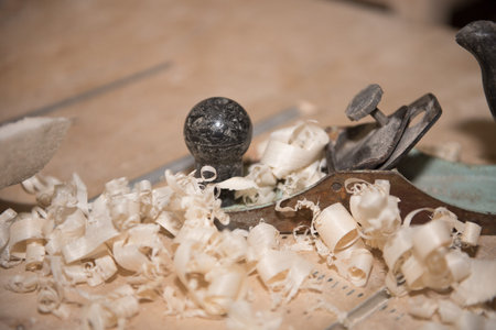 Wood shavings. Planing a tree. Work with a planer. Tools. Planer on the table.