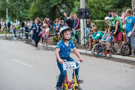 Zarinsk, Russia-June 20, 2019: children ride bicycles, children's competitions, a child on a Bicycle in the foregroundのeditorial素材