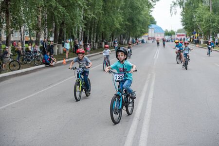 Zarinsk, Russia-June 20, 2019: children ride bicycles, children's competitions, a child on a Bicycle in the foregroundのeditorial素材