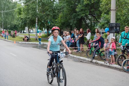 Zarinsk, Russia-June 20, 2019: children ride bicycles, children's competitions, a child on a Bicycle in the foregroundのeditorial素材