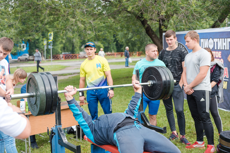 Zarinsk, Russia - July 22, 2019: street performance of bodybuilders. Athletes raise the bar. Street showのeditorial素材