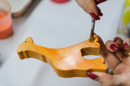 Making wooden toys. Coat toys with natural oil. Safe toys. Girl decorates toys. Educational toys. From natural materials.の写真素材