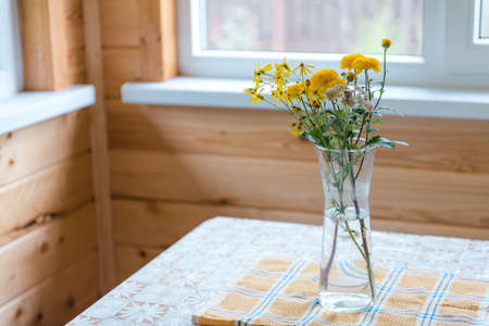 Flowers in a vase on the veranda. Yellow flowers. A bouquet of flowers on the table. Rural landscape. Romantic flowers in the house. Chrysanthemums in a vase. Favorite flowersの写真素材