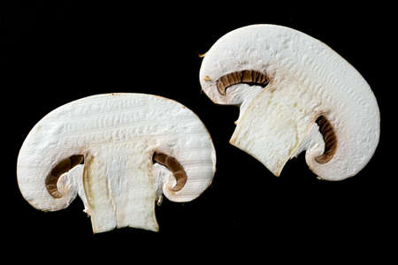 Champignons on a black background. Sliced fresh raw mushrooms.の写真素材