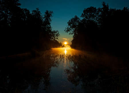 Beautiful sunrise over the river in the early summer morningの写真素材