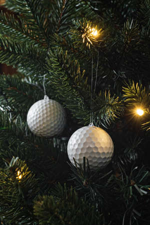 Golf balls as a xmas ornament in fir treeの写真素材