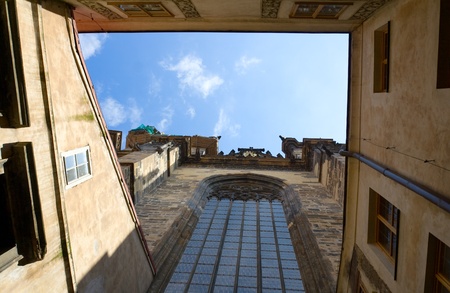 View on blue cloudy sky from inner encloused court of stone catholic gothic church of Virgin Mary Before Tyn with round-headed glass window in Prague Czech Republic の写真素材