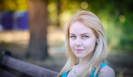 Young pretty blonde girl walking in the parkの写真素材
