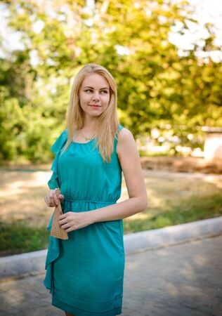 Young pretty blonde girl walking in the parkの写真素材