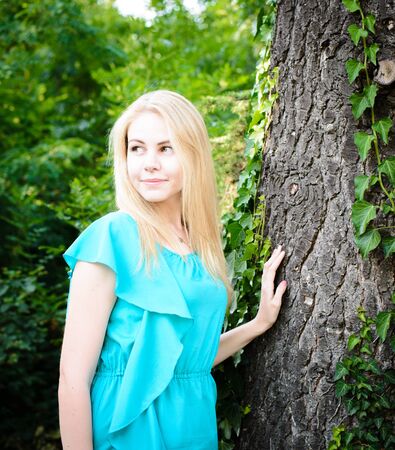 Young pretty blonde girl walking in the parkの写真素材