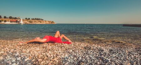Sexy girl in a dress on a beachの写真素材