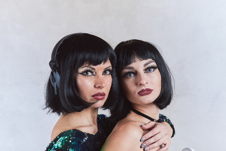 Two sexy brunettes in a green dress
