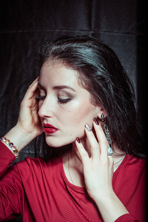 A portrait of a young pretty brunette on a dark backgroundの写真素材