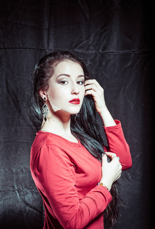 A portrait of a young pretty brunette on a dark backgroundの写真素材