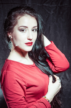 A portrait of a young pretty brunette on a dark backgroundの写真素材