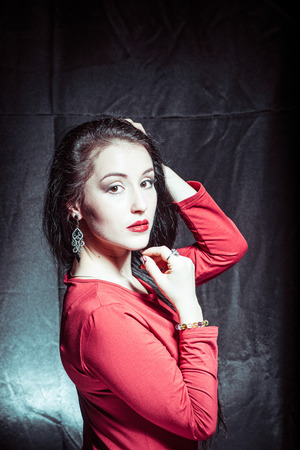 A portrait of a young pretty brunette on a dark backgroundの写真素材