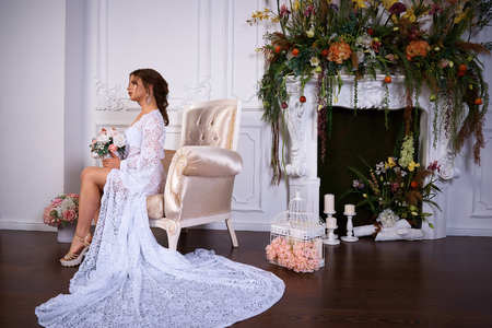 A portrait of a young pretty brunette in a long white dressの写真素材