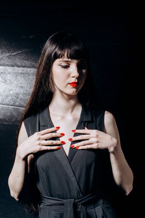 Hot brunette with a red lips on a black backgroundの写真素材
