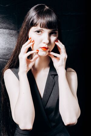 Hot brunette with a red lips in a black dressの写真素材