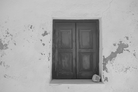 A hot day and a window with shutters in the wall of a house in Emporio on Santorini, Greeceの写真素材