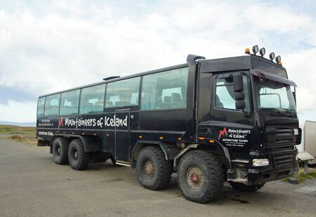 Summer day in the south of Iceland and a tourist bus all-terrain vehicle on a car siteの写真素材