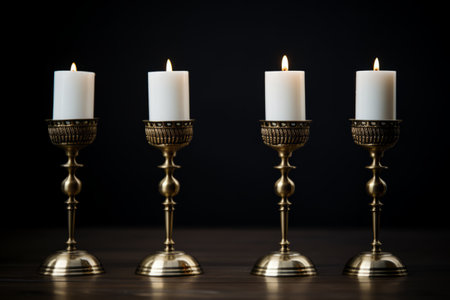 Glowing Elegance: Four White Tealight Candles on Brass-colored Candlesticks --ar 3:2の素材