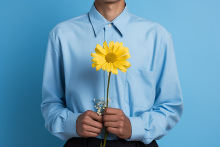 Floral Elegance: A Person in a Blue Dress Shirt Embracing a Vibrant Yellow Flower --ar 3:2の素材