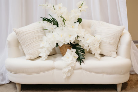 Charming White Fabric Loveseat Adorned with Delicate Flower Centerpieces --ar 3:2の素材