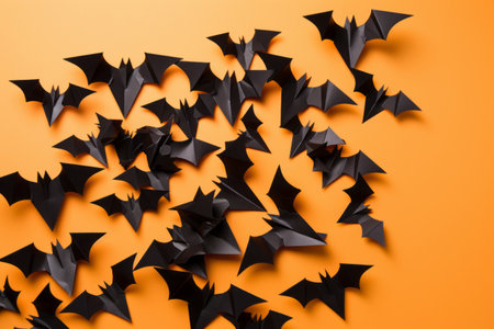 Dark Shadows: Black Paper Bats Soaring Against an Orange Backgroundの素材