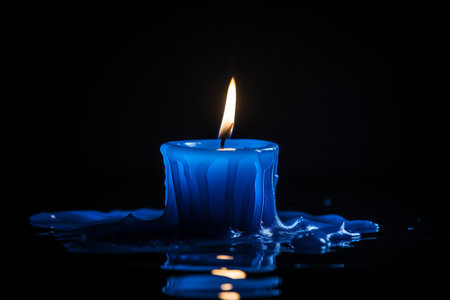 Mystic Glow: Mesmerizing Blue Candle Shines Amidst a Deep Darknessの素材