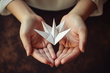 Picturing Serenity: Capturing a Girls Tranquil Paper Crane Origami Creation in Stunning Top Viewの素材