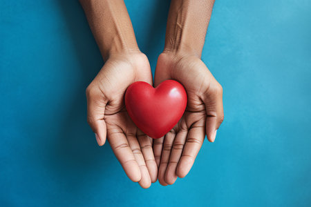 Expressing Love: Intimate Close-Up of Hands Grasping a Red Heart Against a Serene Blue Background --の素材