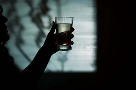 Glimpse into Mysterious Shadows: Capturing the Elegance of a Womans Hand Holding a Glass - AR 3:2の素材