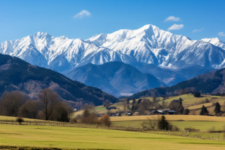 A Mesmerizing Tapestry: Late Autumn's Green Fields amidst Snow-Capped Peaks of the Tokachidake Mountain Rangeの素材