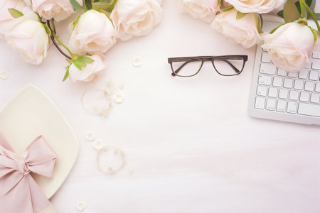 Feminine Haven: A Beautifully Curated Flat Lay Home Office Desk, Embellished with Pink and Beige Roses Bouquet, Charming Accessories, Diary, and Glasses, Upon a Serene White Wooden Backgroundの素材