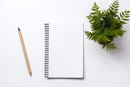 Green Inspiration: Captivating Top View of Notebook, Pencil, and Potted Plant on a Pristine White Deskの素材
