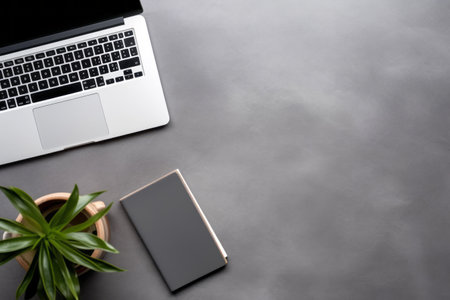 Efficient Workspace: Organized Office Desk Setup with Laptop and Supplies on Sleek Gray Backgroundの素材