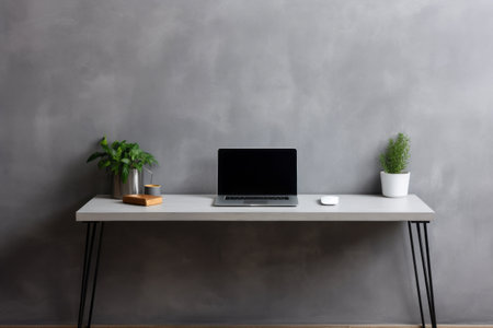 Sleek and Modern Office Setup: Featuring a Business Work Table with Laptop and Phone on Grey Wallの素材