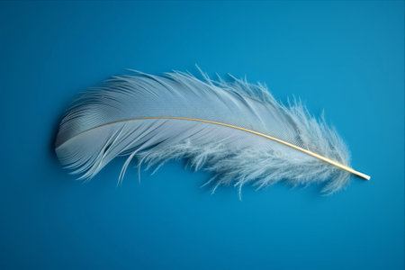 Gracefully Floating: Feather on Blue Background - A Captivating 3:2 Perspectiveの素材