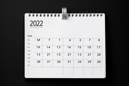 Efficiently Organizing Your Days: A Close-Up on the White Calendar 2022 for Easy Appointment Management and Timetable Coordination on a Striking Black Background - 3:2 Aspect Ratioの素材