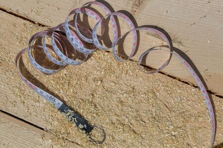 Construction tape measure in sawdust.